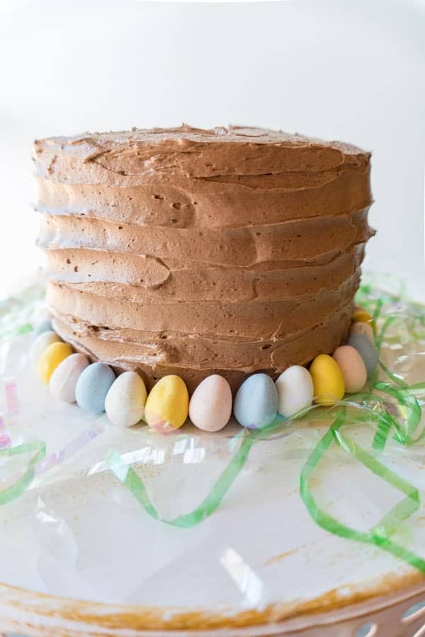 This fun and Easy Easter cake will satisfy any sweet-tooth! An amazing yellow cake recipe, with vanilla and chocolate buttercream frosting- it is out of this world good! #easter #yellowcake #cakedecorating #easy #homemade #fromscratch #atablefullofjoy #dessert