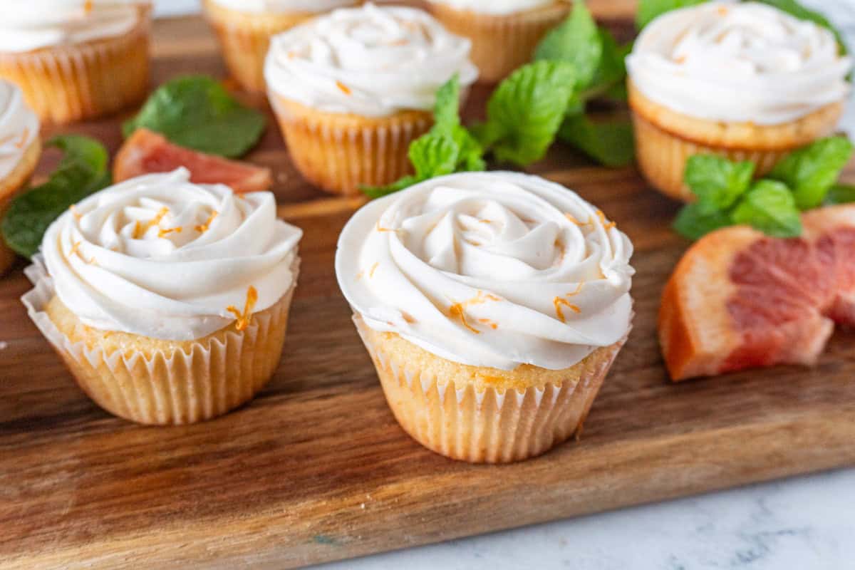 grapefruit cupcakes on wood cutting board.