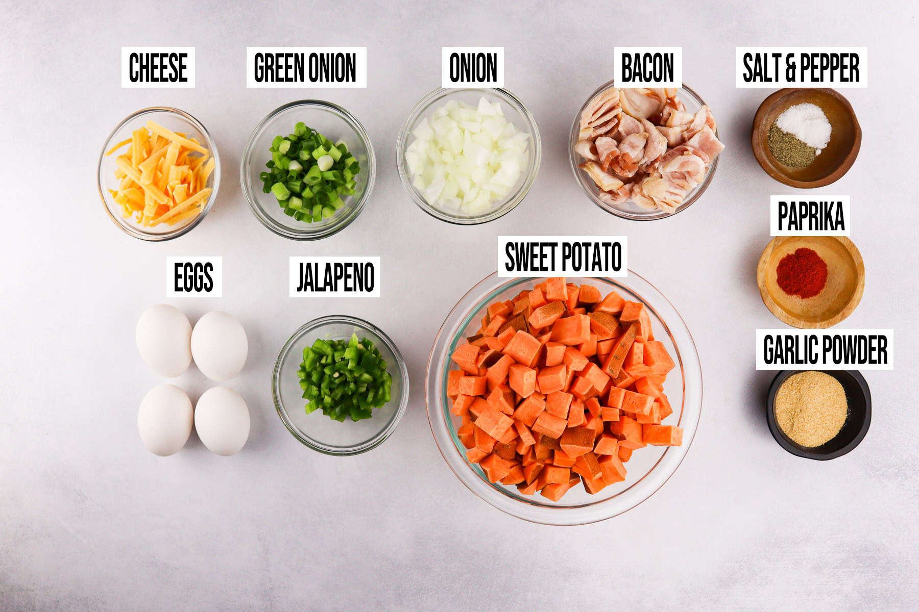 sweet potato breakfast skillet ingredients in individual bowls and labeled.
