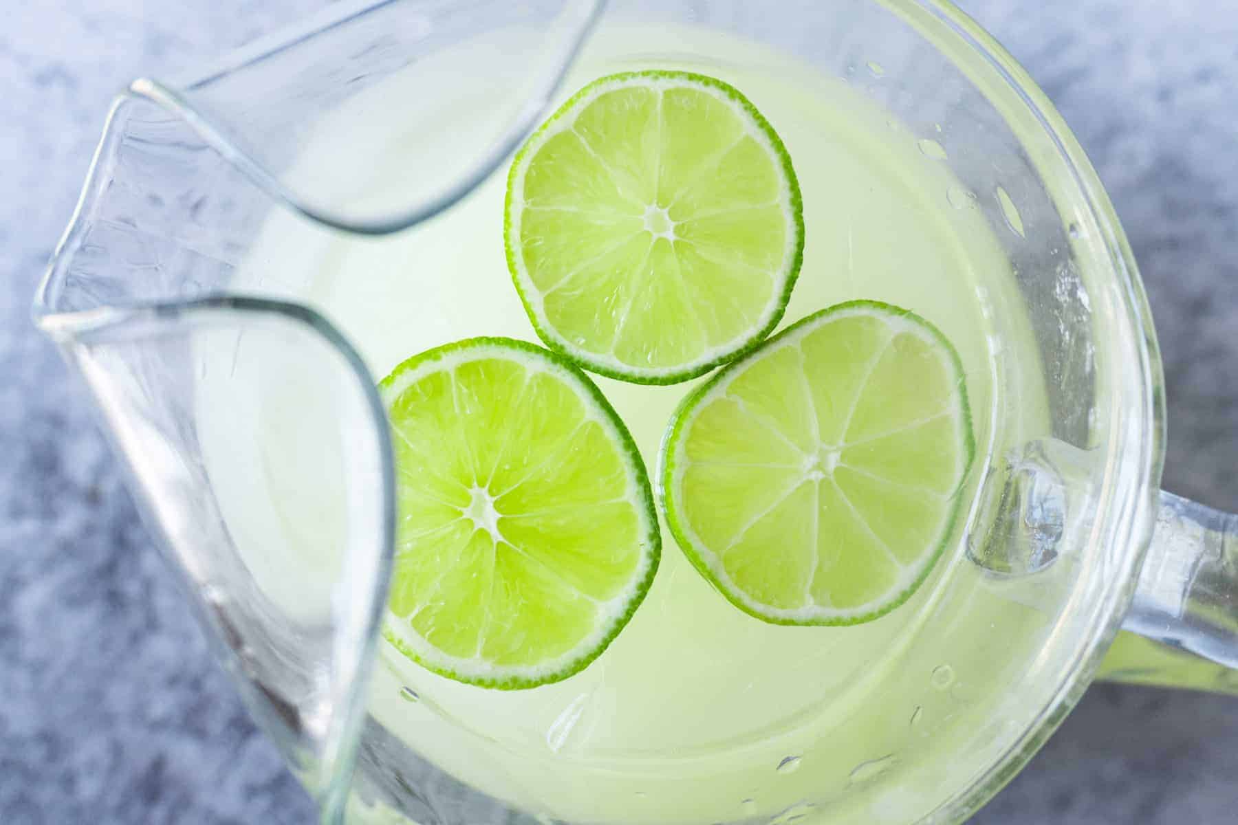 Pitcher of homemade limeade with lime wedges