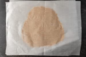 cookie dough rolled flat between two pieces of parchment paper.