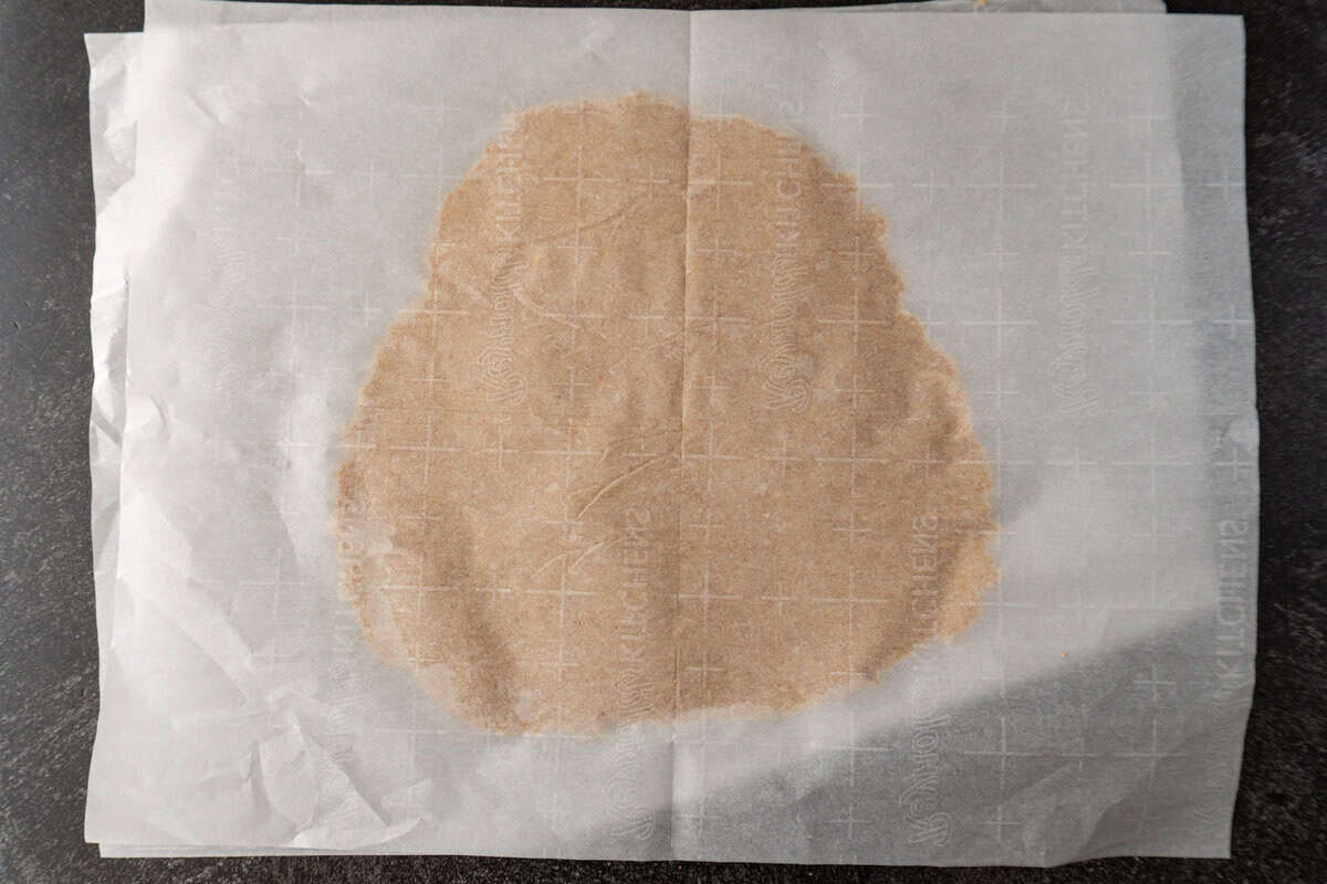 cookie dough rolled flat between two pieces of parchment paper.