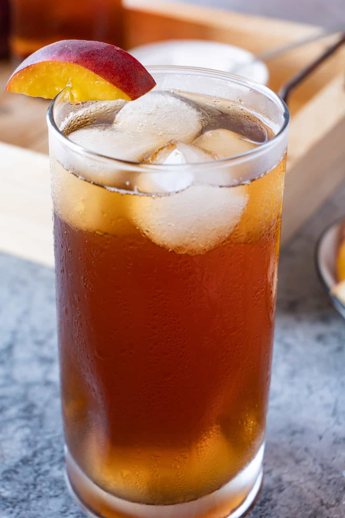 peach iced tea in glass with ice cubes