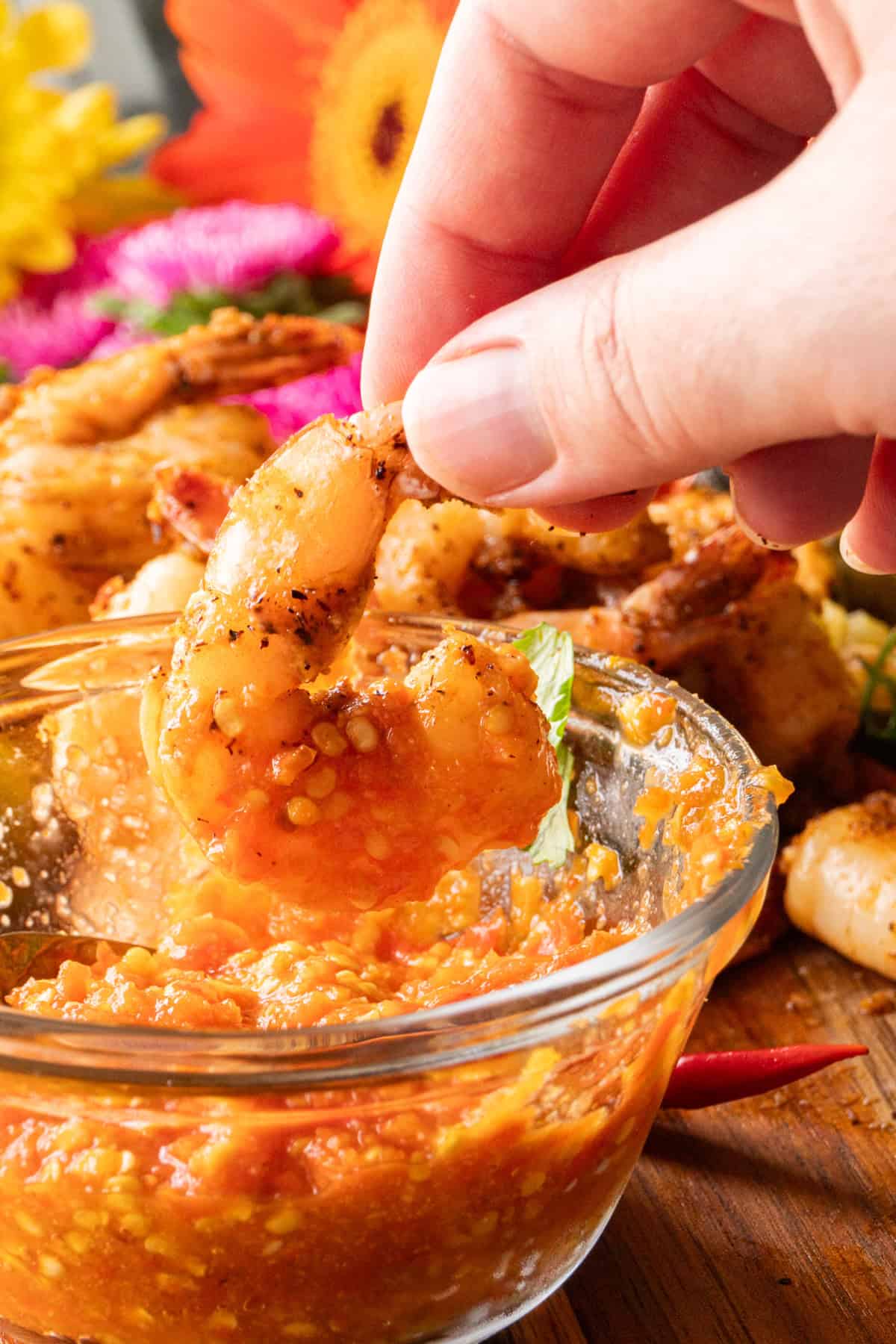 dipping a piece of shirmp into hot sauce