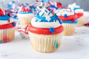 red white and blue cupcakes with decorations in background