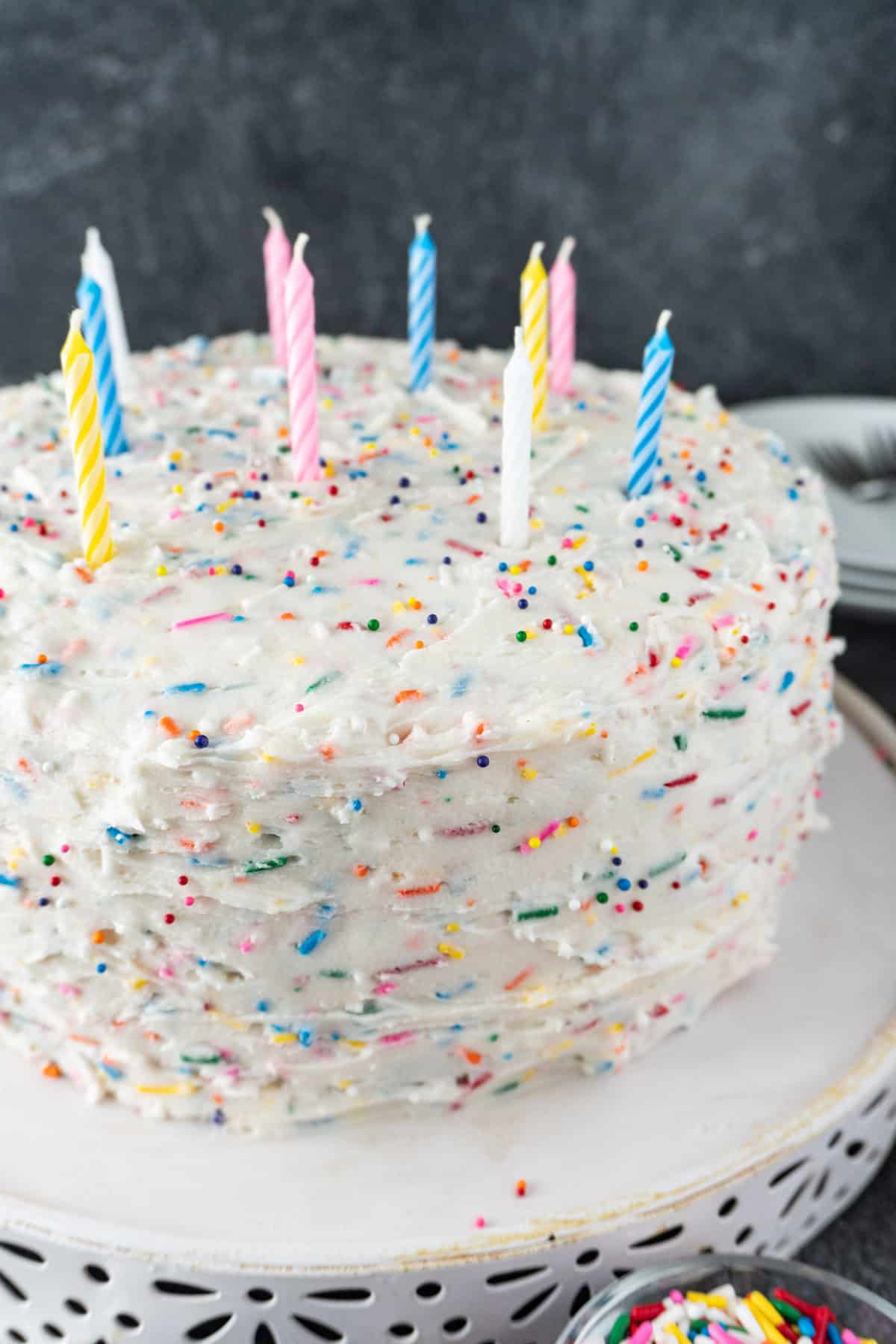 Birthday cake with funfettie frosting and colorful candles.