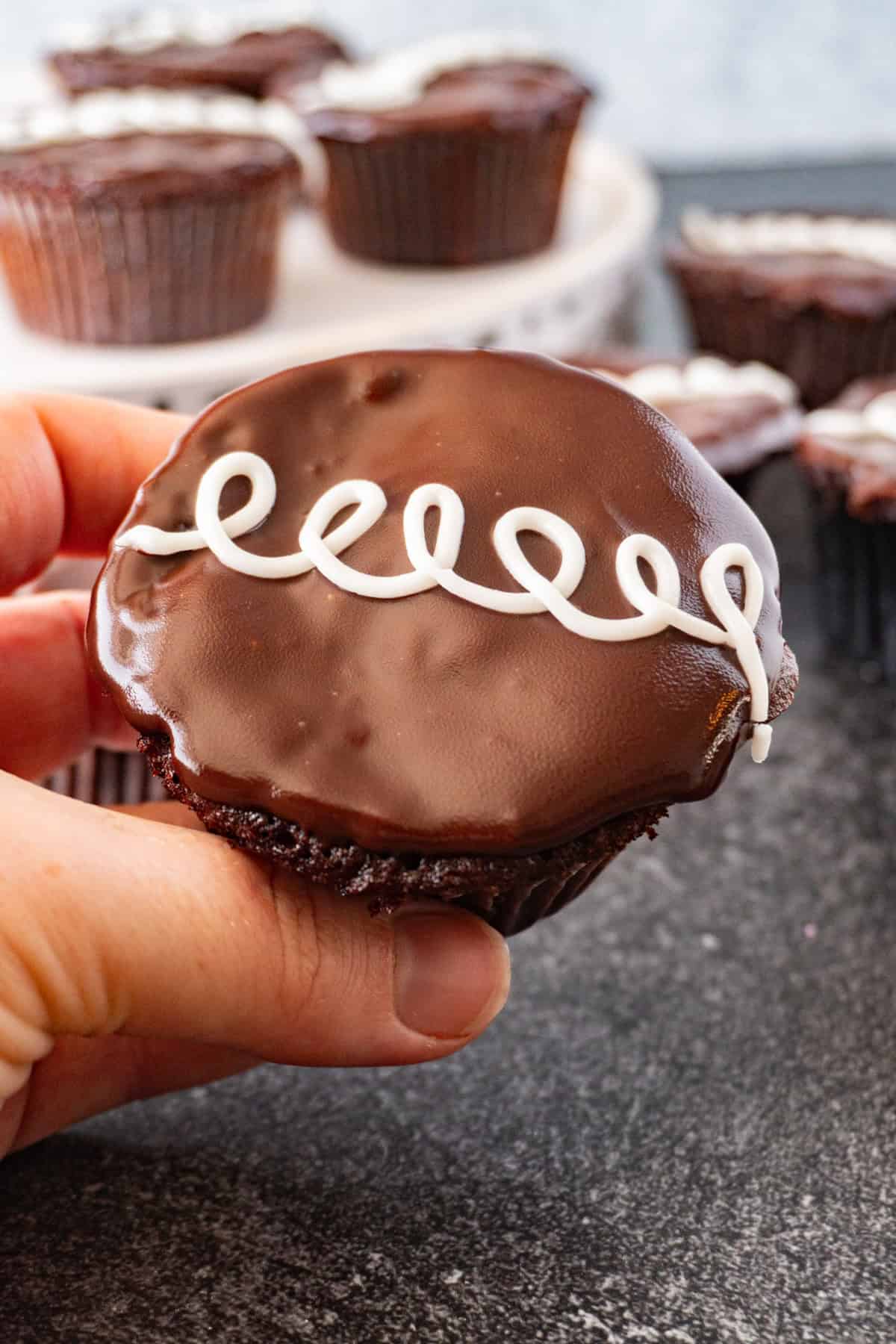 holding a cream filled cupcake.