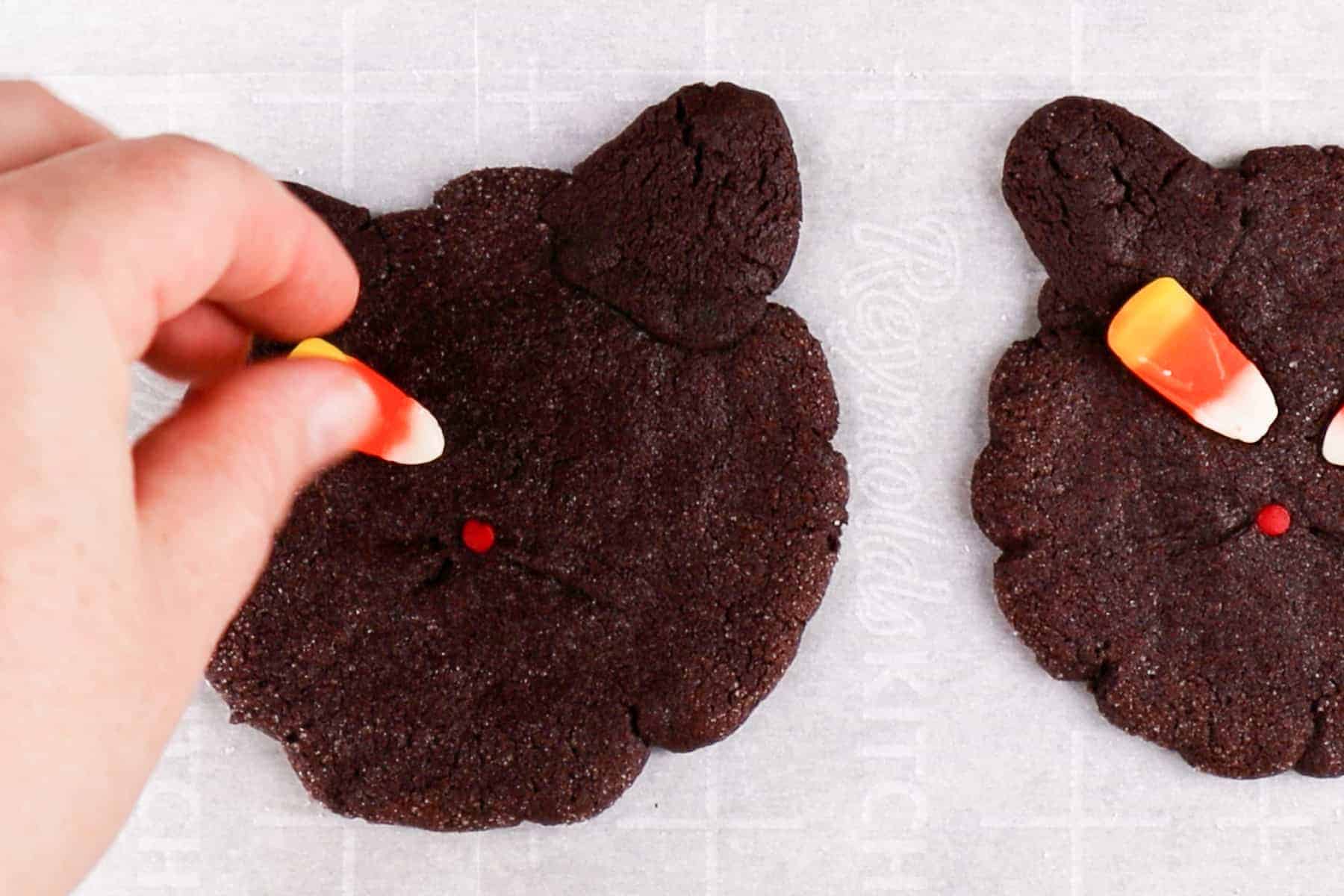 pressing candy corn eyes onto warm cookies.