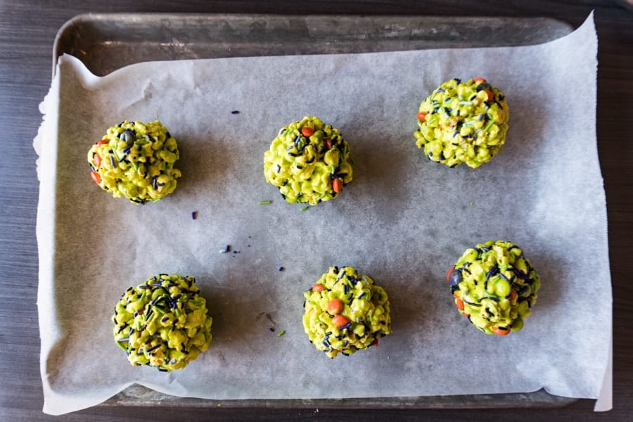 popcorn balls shaped into balls and on a parchment-lined tray.