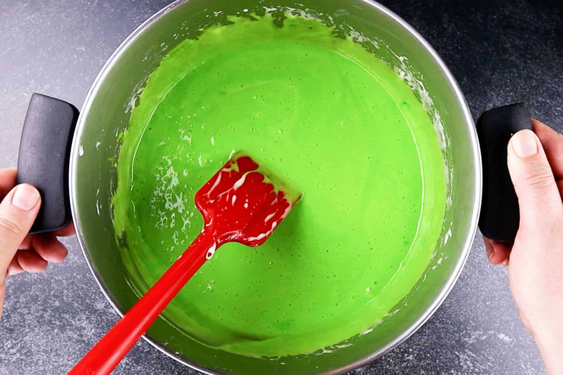 melted marshmallow and butter mixed with neon green food coloring, in a large pot.