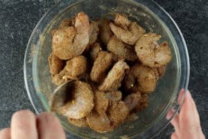 tossing shrimp in seasoning