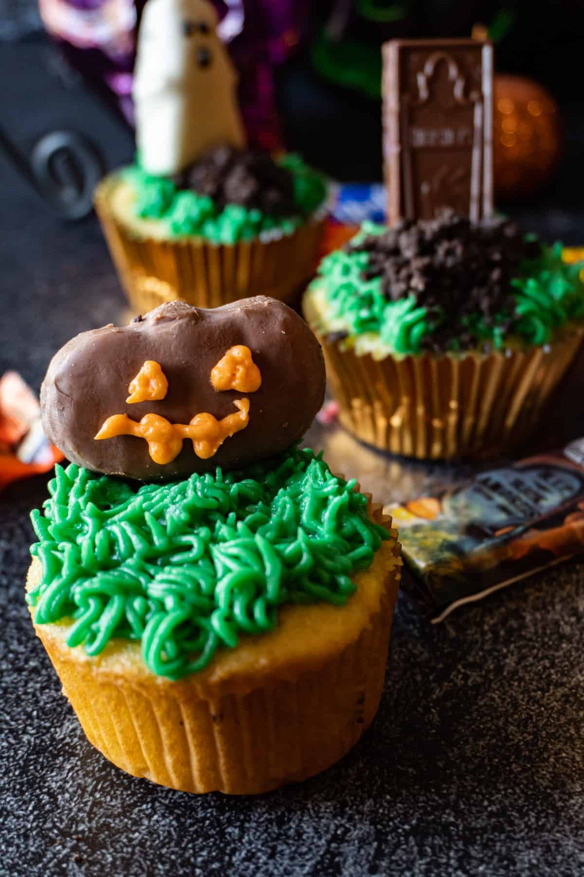 Halloween Graveyard Cupcake with Reese's Chocolate Pumpkin added to the frosted green grass on the cupcake.