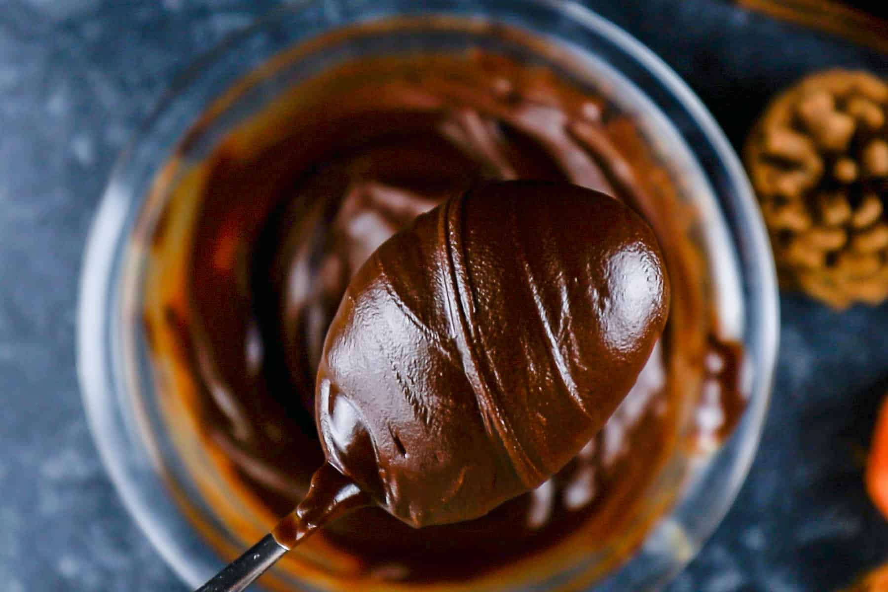 Melted chocolate chips and butter in a glass bowl and scooped out with a spoon.