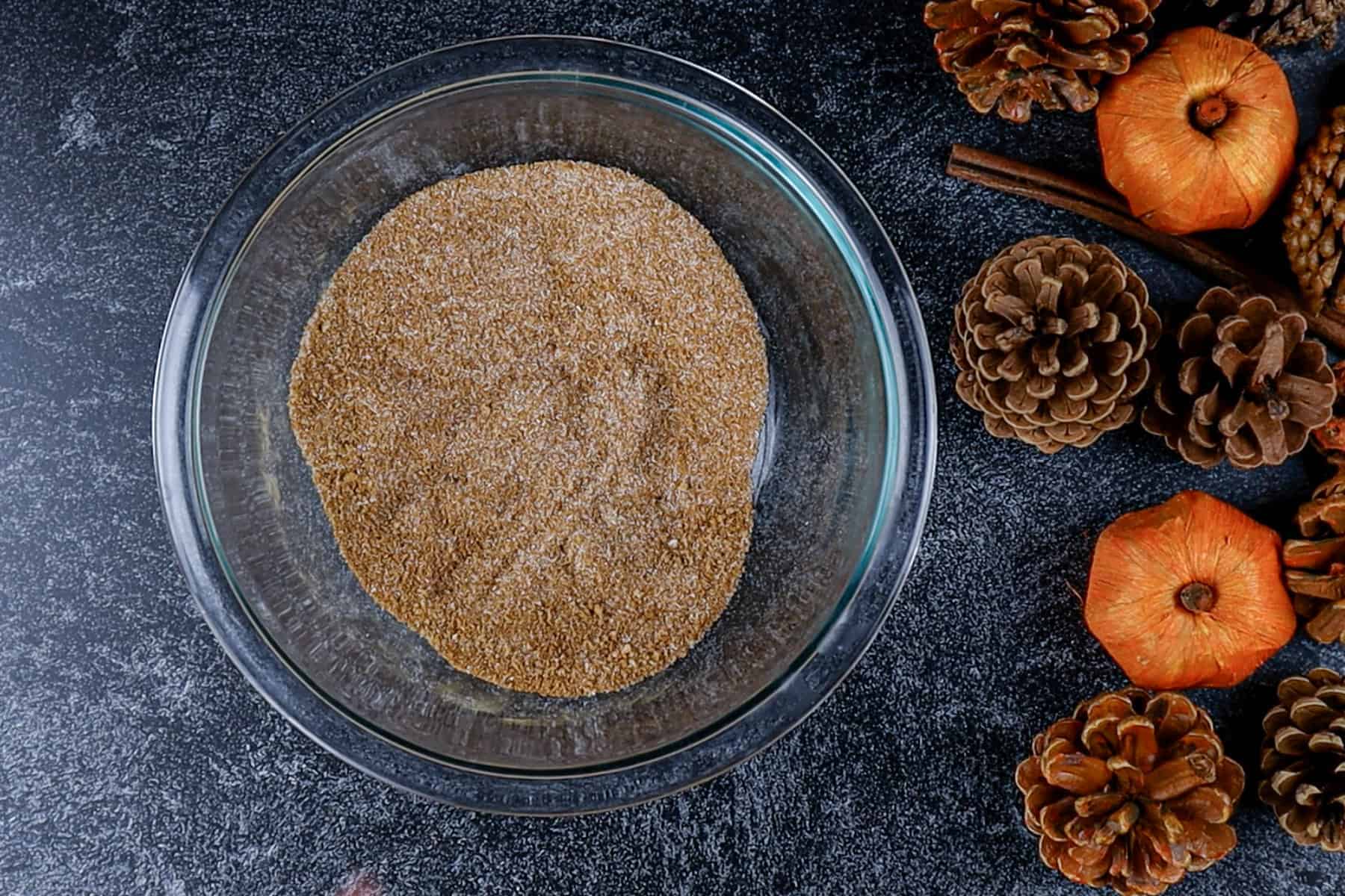 Sugars and spices are mixed in a glass bowl.