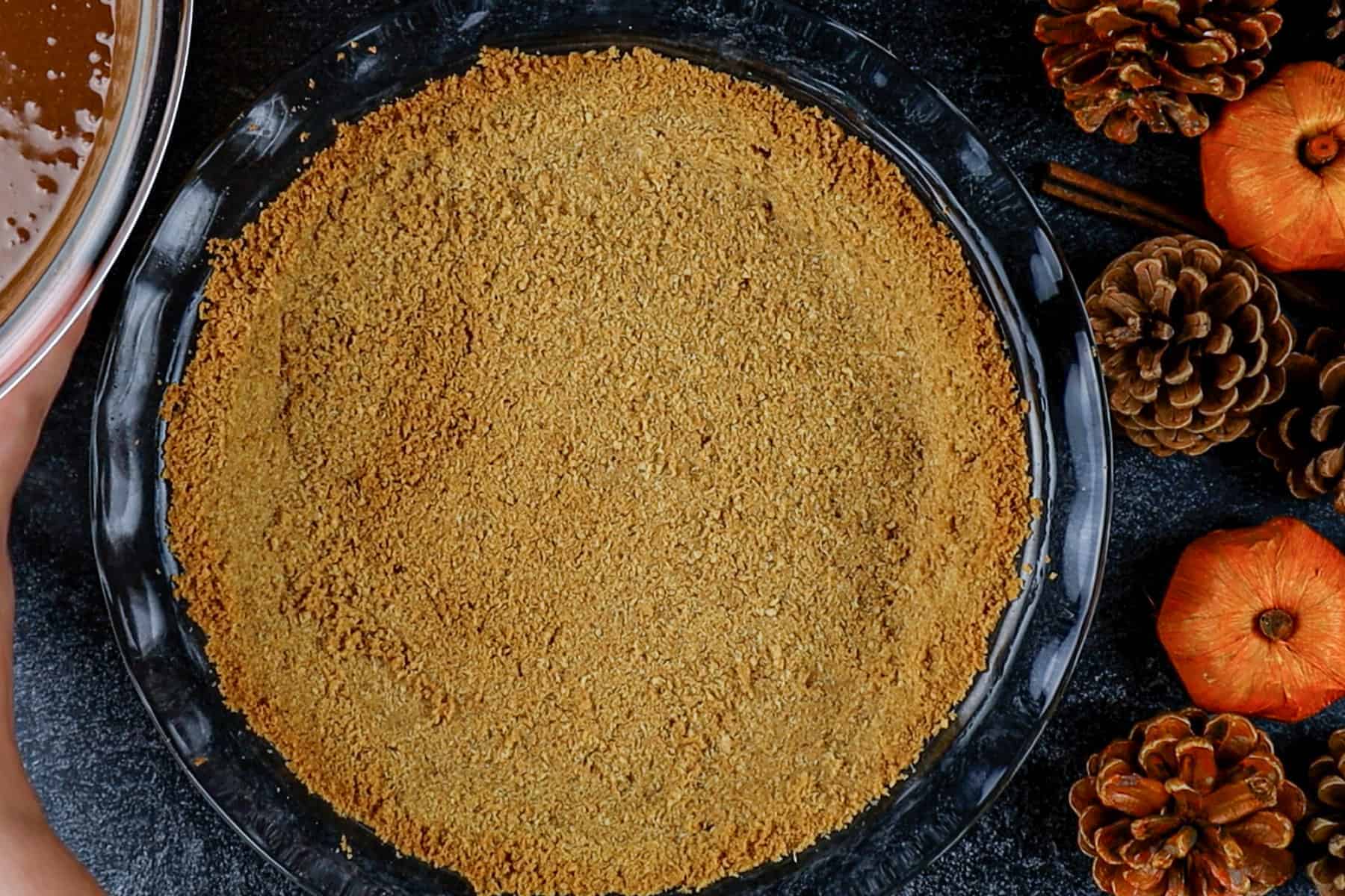 Graham cracker crust baked in a glass pie dish.