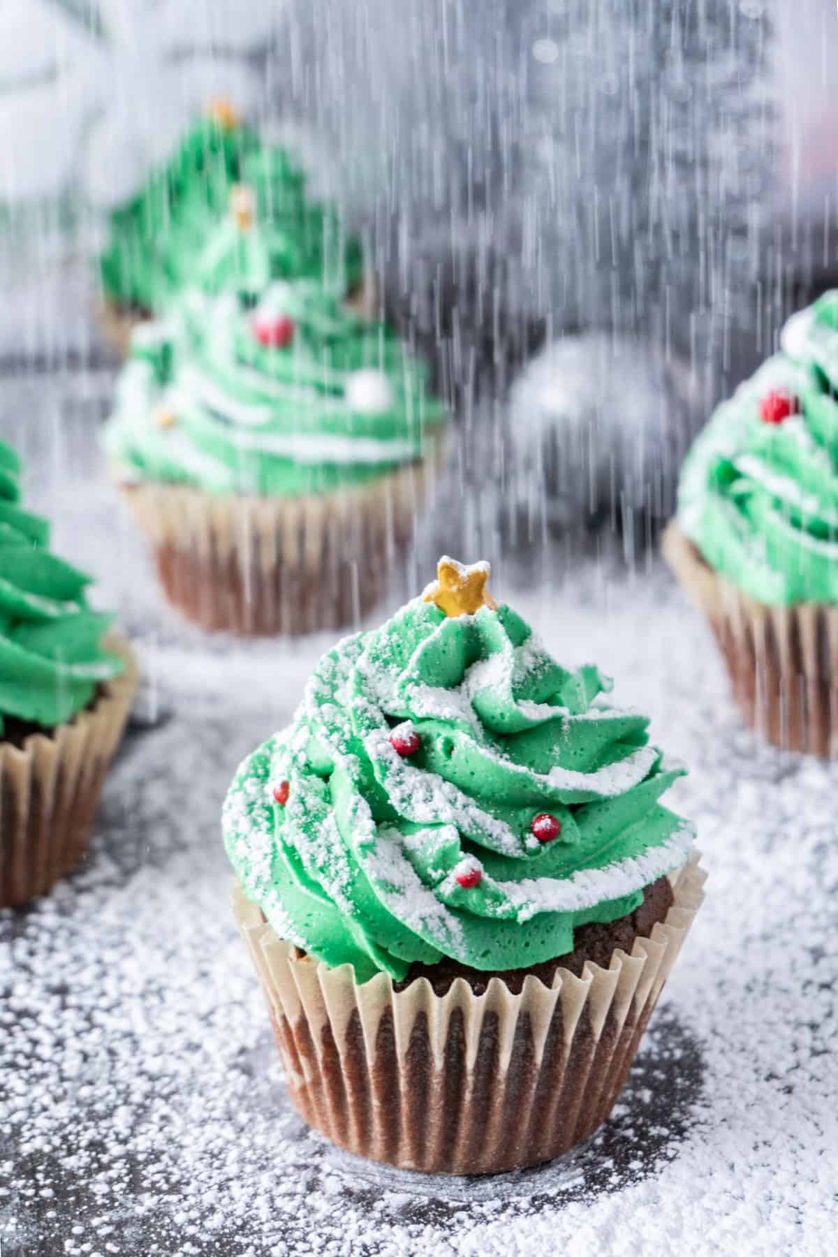 Christmas Tree Cupcakes with powdered sugar "snowing" on them