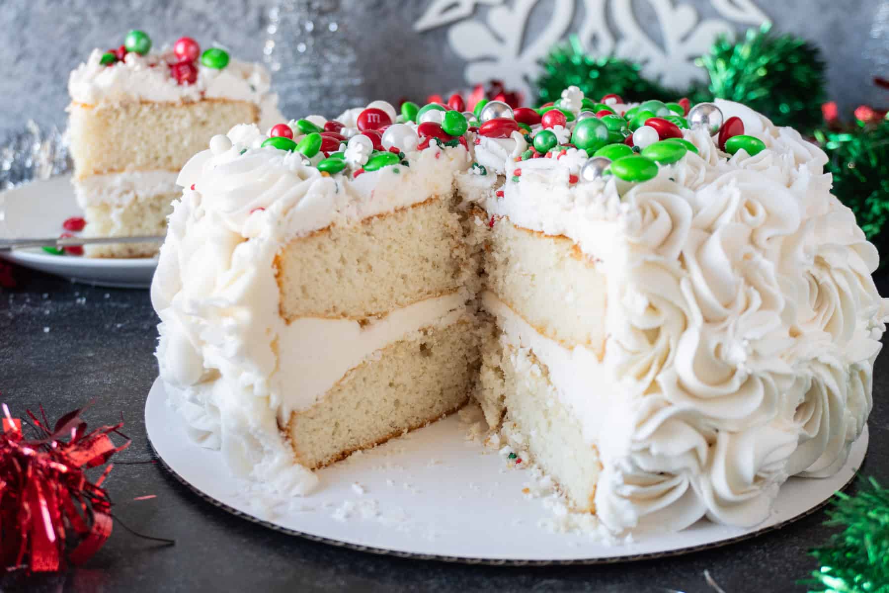 Easy Holiday cake with slice cut out showing the two layers and beautiful buttercream swirls.