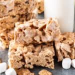 cinnamon toast crunch bars with mini marshmallows sprinkled around them and milk in a cup, featured image.