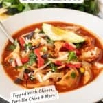 chicken tortilla soup in white bowl garnished with avocado, chips, green onions, pinterest pin.