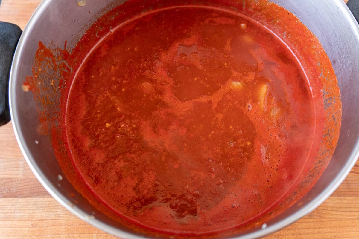 crushed tomatoes and broth added to soup pot.
