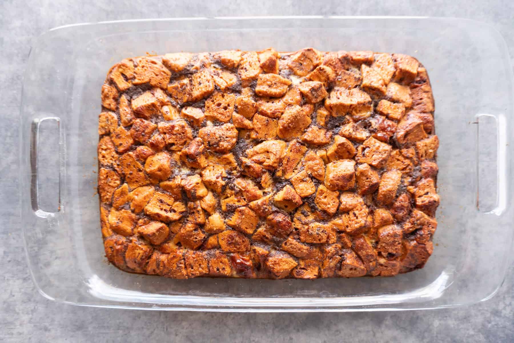 After baking the cinnamon rolls and egg mixture in a casserole pan, showing a golden brown top.