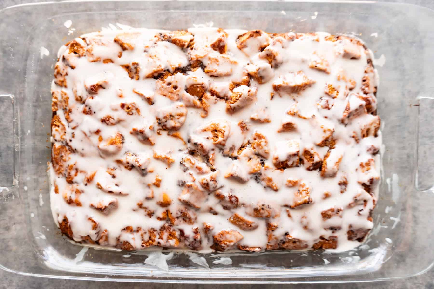 Cinnamon Roll French Toast, baked and frosted in casserole pan.