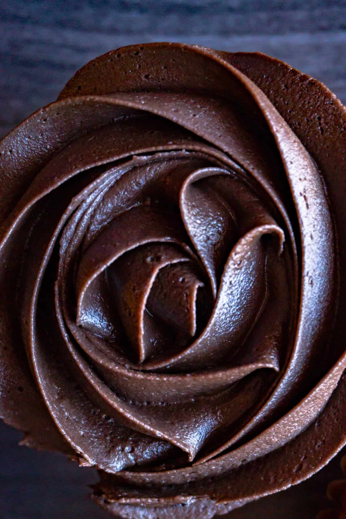 dark chocolate buttercream frosting swirled on top of cupcake
