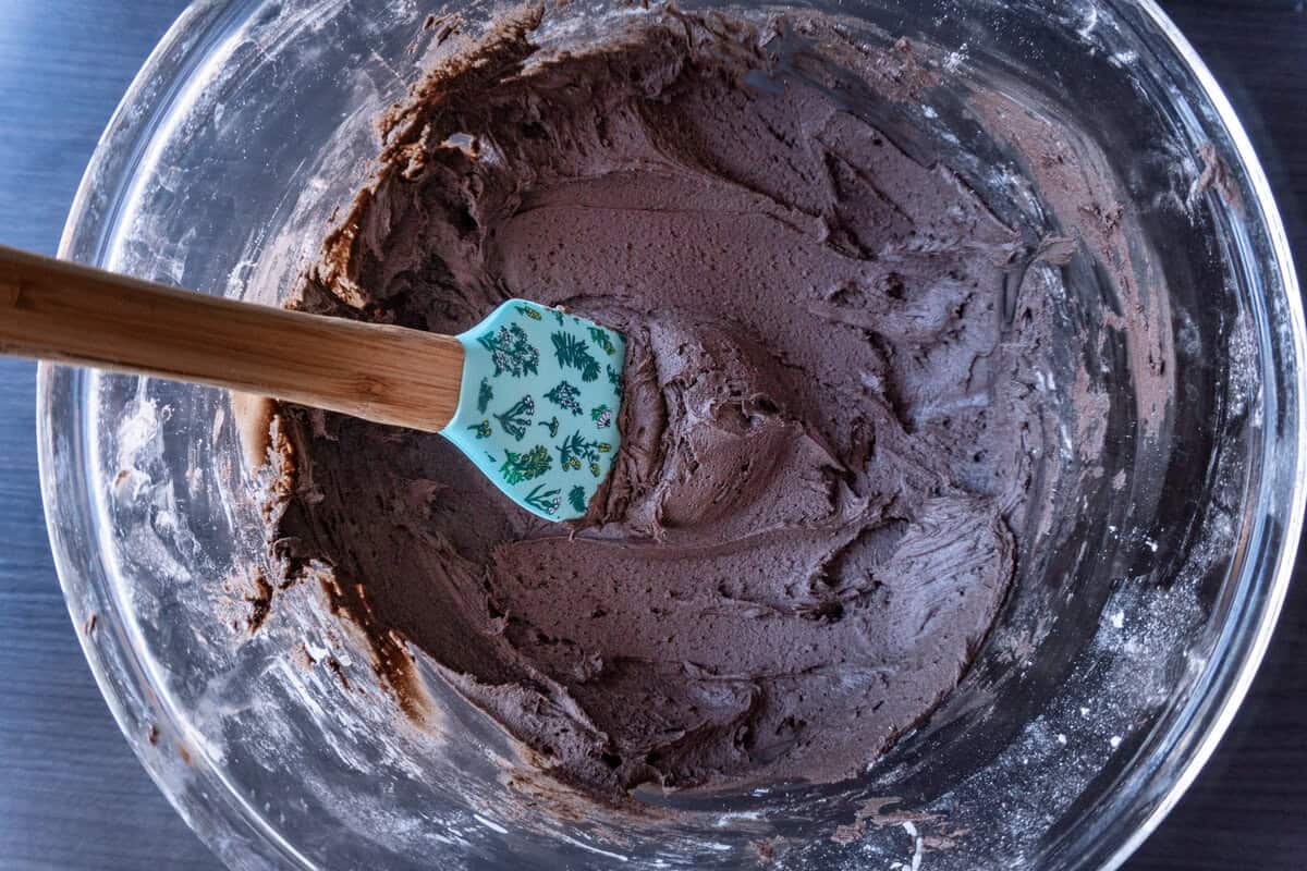 Dark chocolate buttercream in a glass mixing bowl.