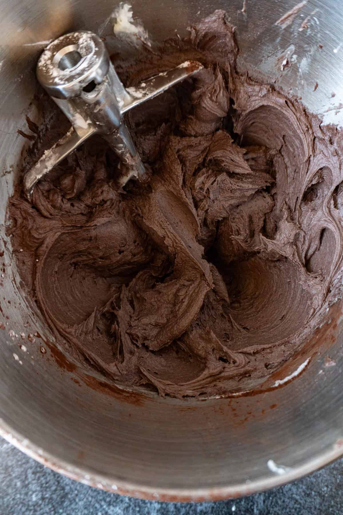 dark chocolate buttercream frosting in metal mixing bowl.