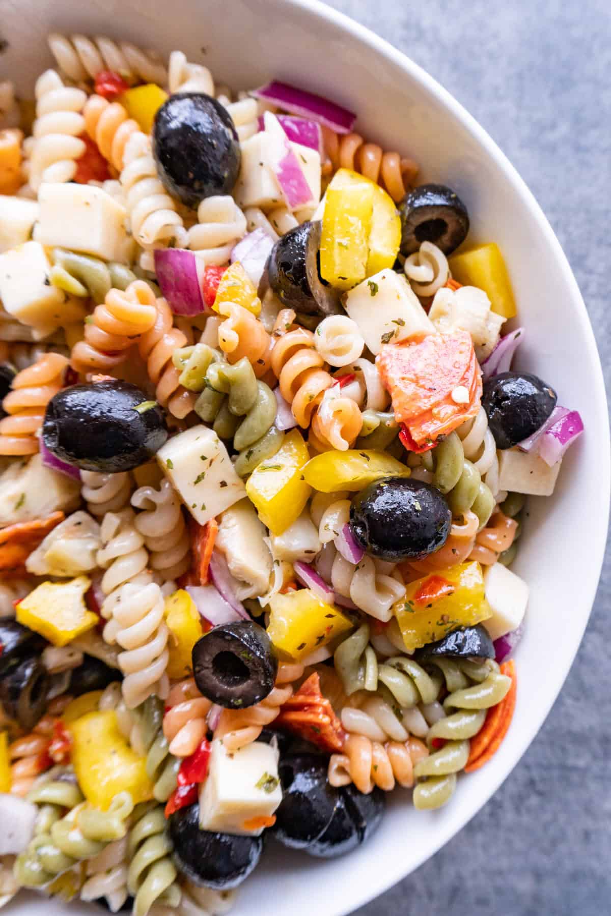 close up of pepperoni pasta salad in large white bowl