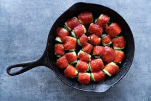 adding pasta sauce to zucchini