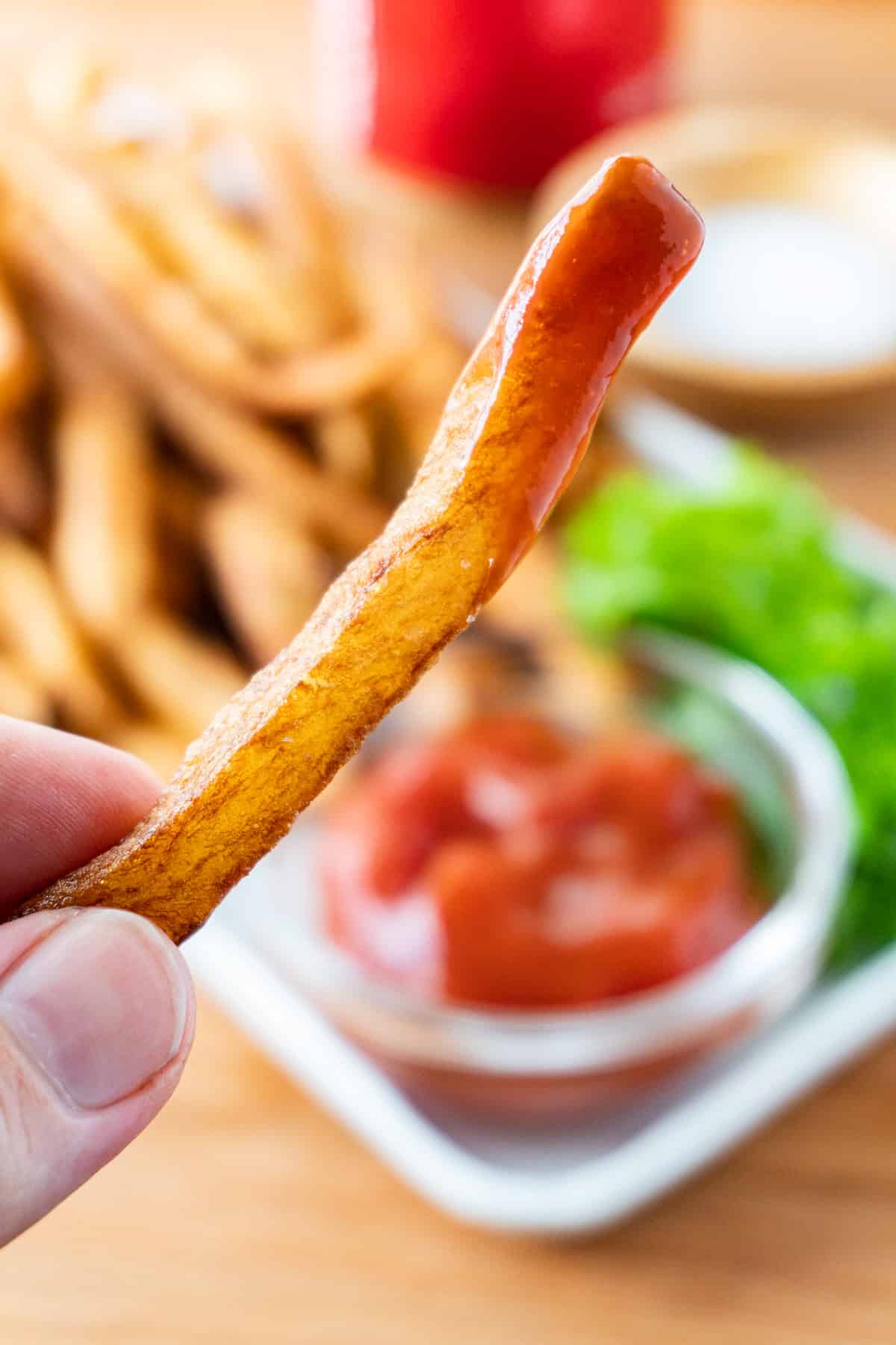 fried french fry dipped in ketchup
