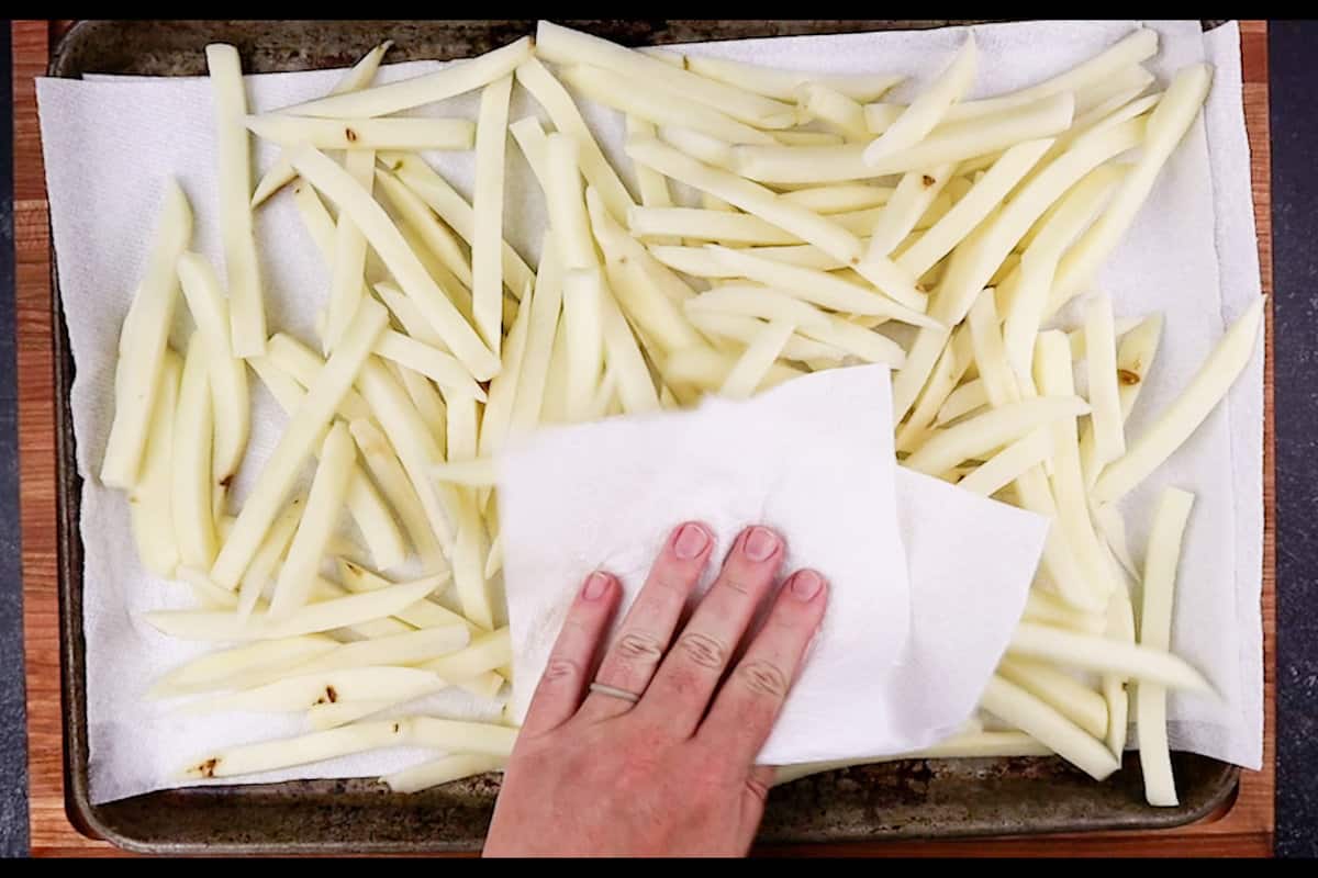 patting cut potatoes dry