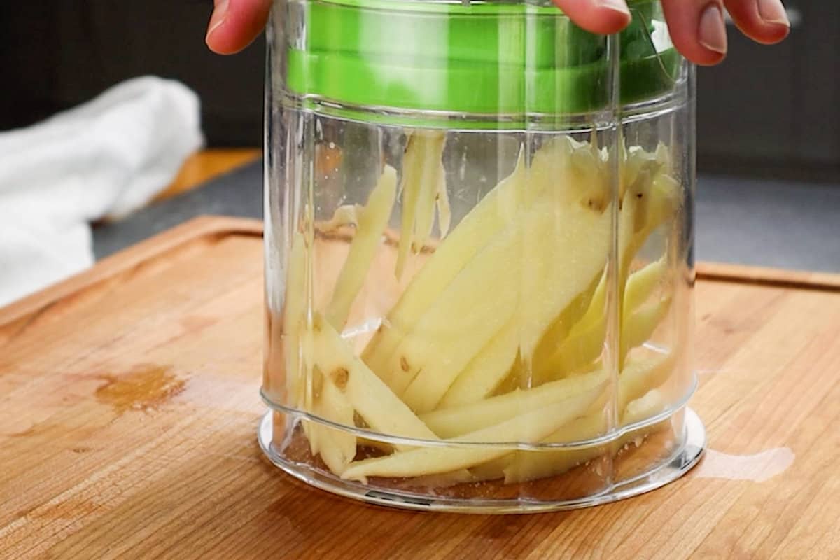 using a french fry cutter to cut potatoes