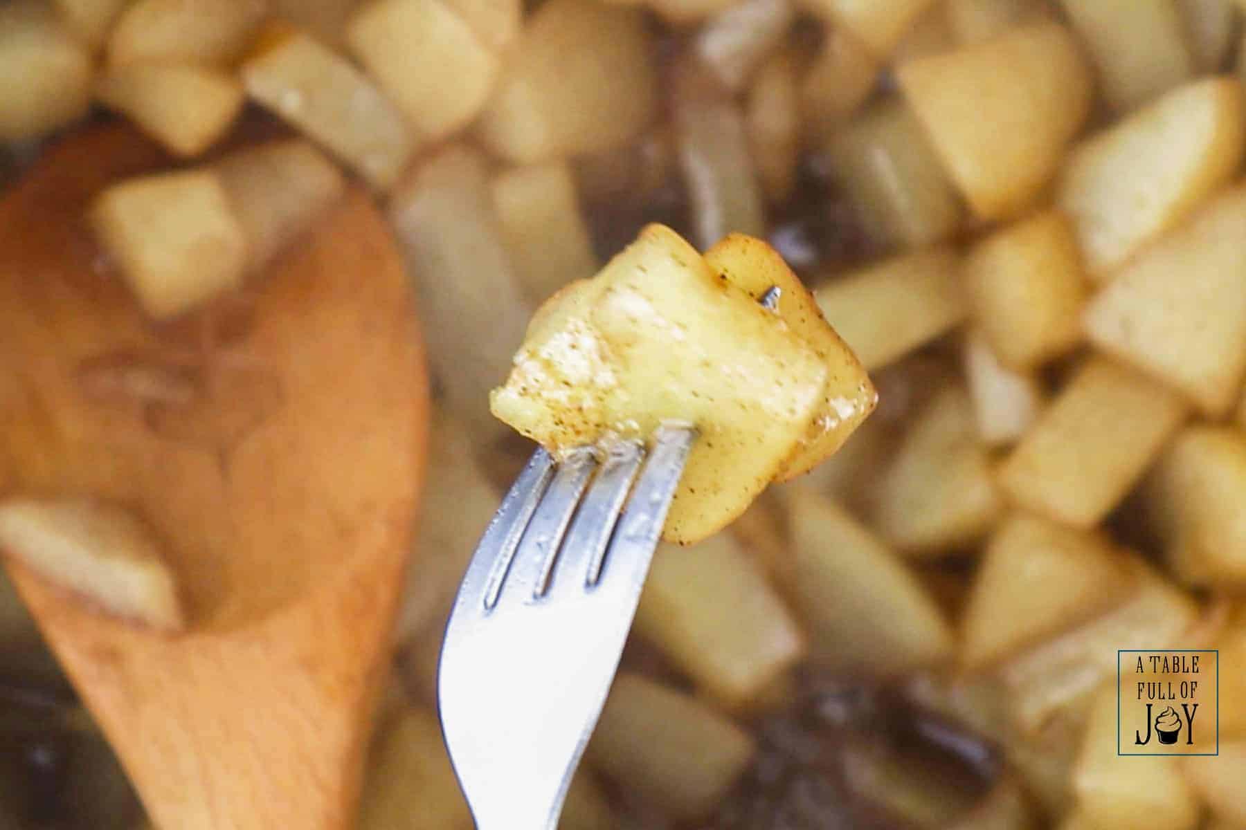 Cooked pears are stabbed with a fork to show tenderness.