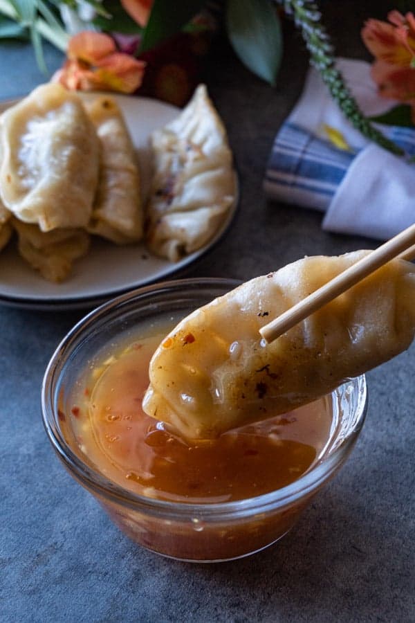 Pot sticker being dipped in Asian Dipping Sauce