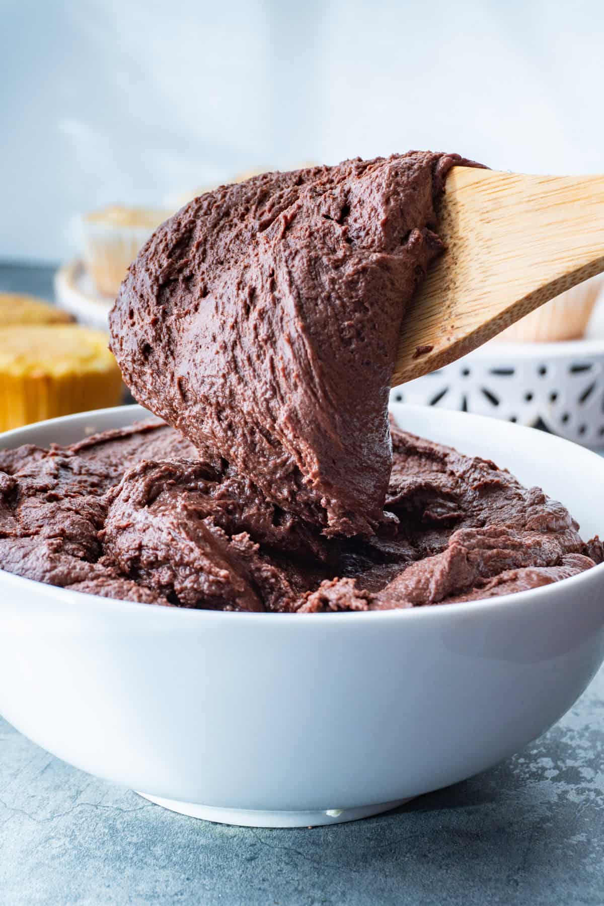 chocolate fudge frosting on end of wooden spoon.
