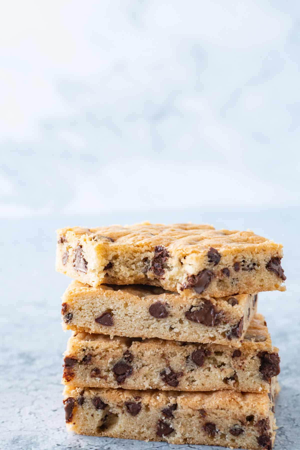 chocolate chip cookie bars stacked with bite taken out of top