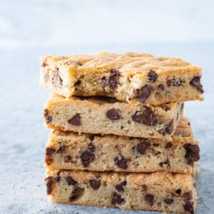 chocolate chip cookie bars stacked with bite taken out of top featured image