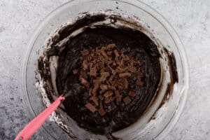 mixing chocolate into brownie batter