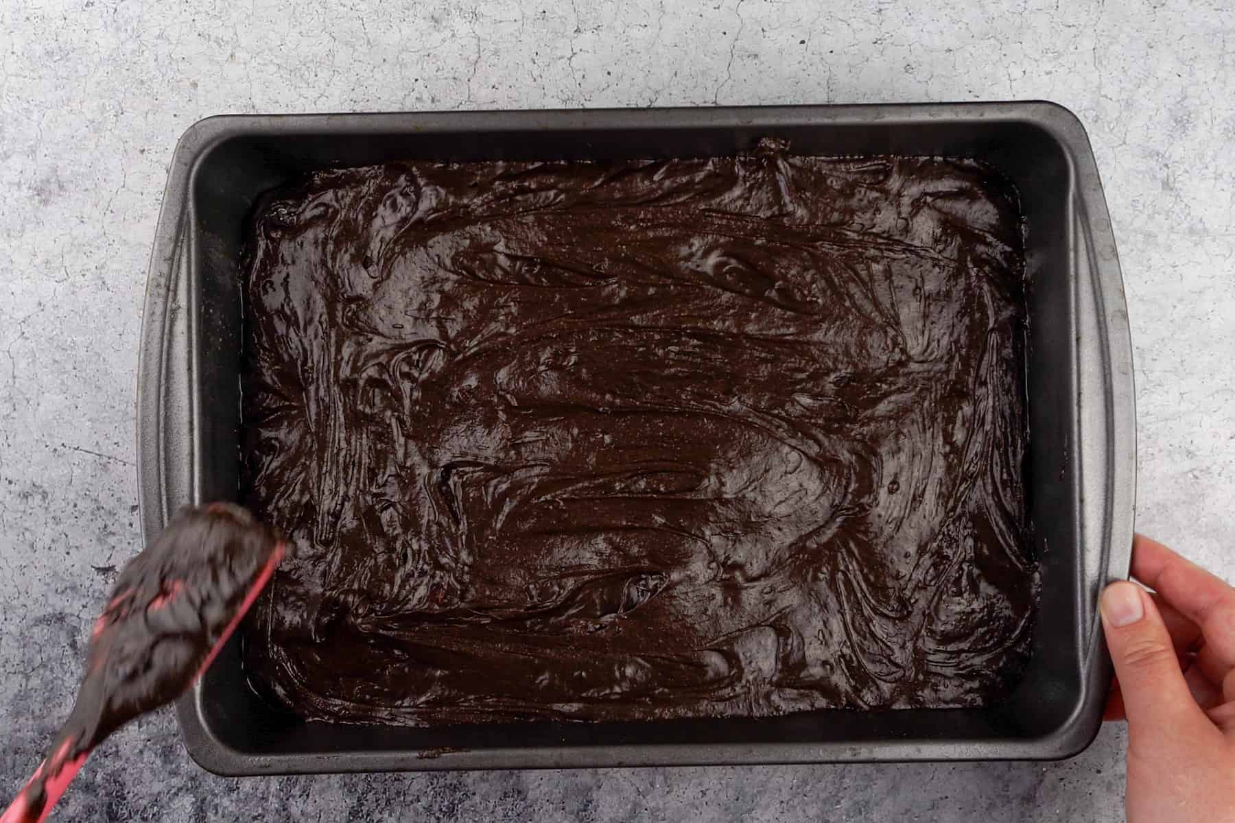 spreading brownie batter in pan