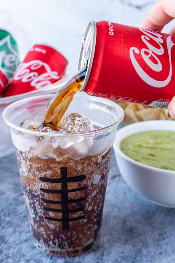 Coke being pourn into a cup with football laces drawn on it