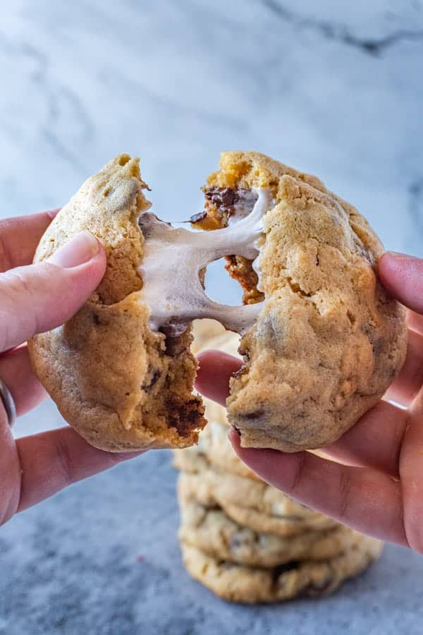 S'mores Stuffed Cookies being pulled apart with gooey marshmallow in center