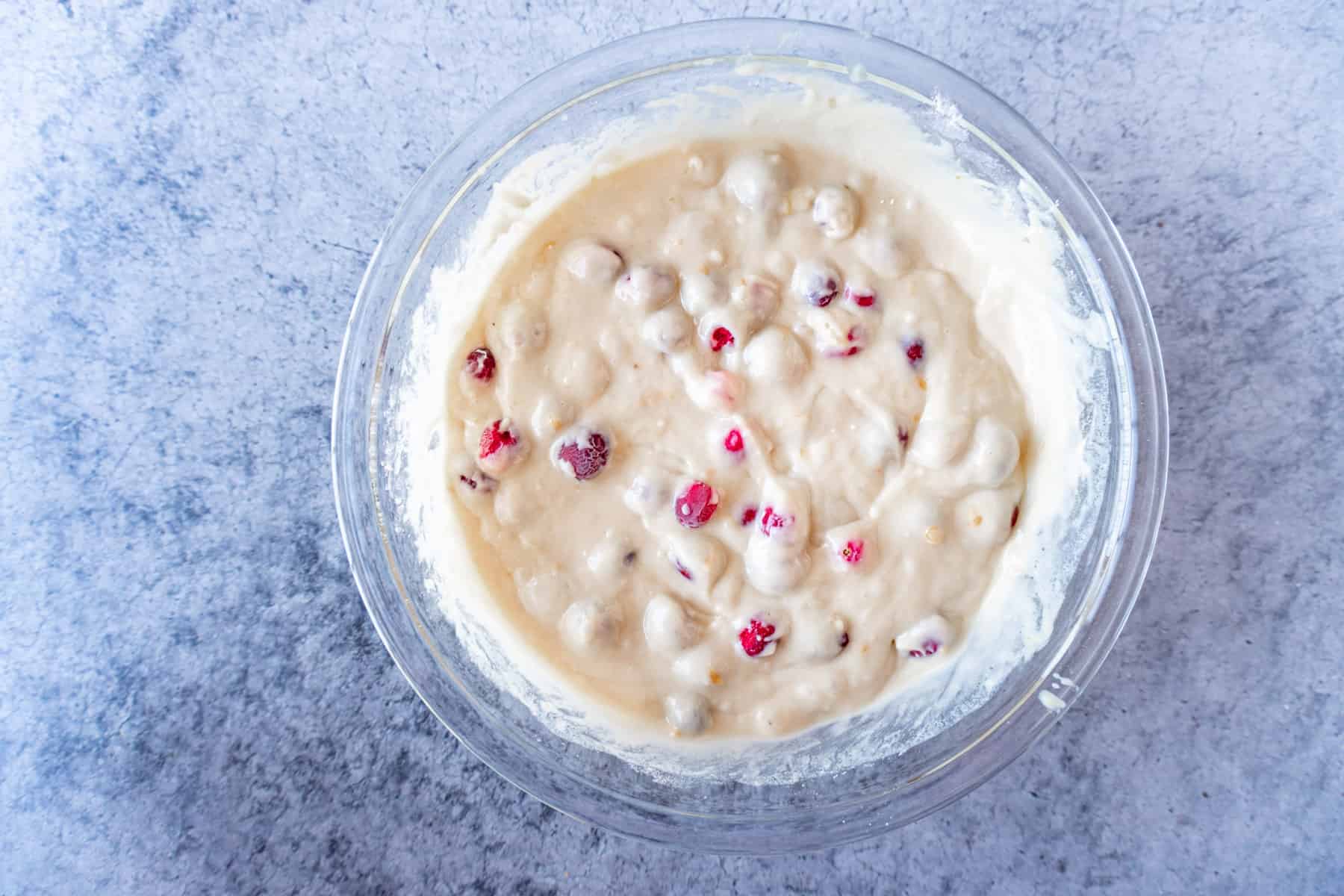 cranberry orange muffin batter mixed in glass bowl
