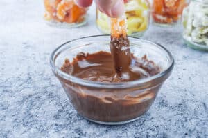 candied orange being dipped in chocolate