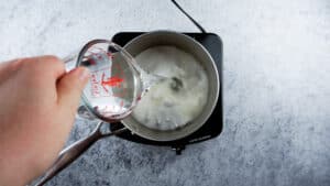 adding water to sugar in saucepan