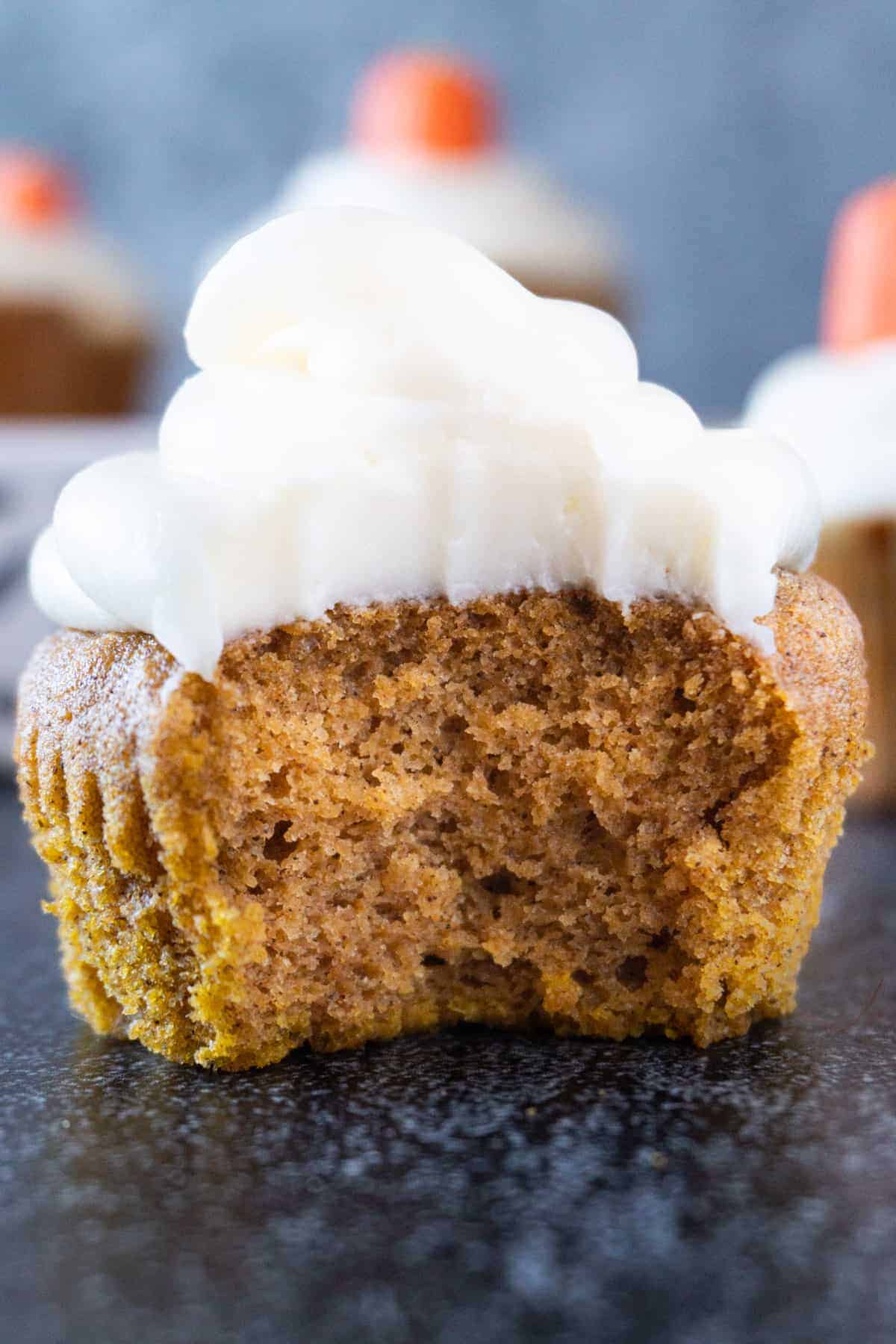 pumpkin cupcake with cream cheese frosting with bite taken out