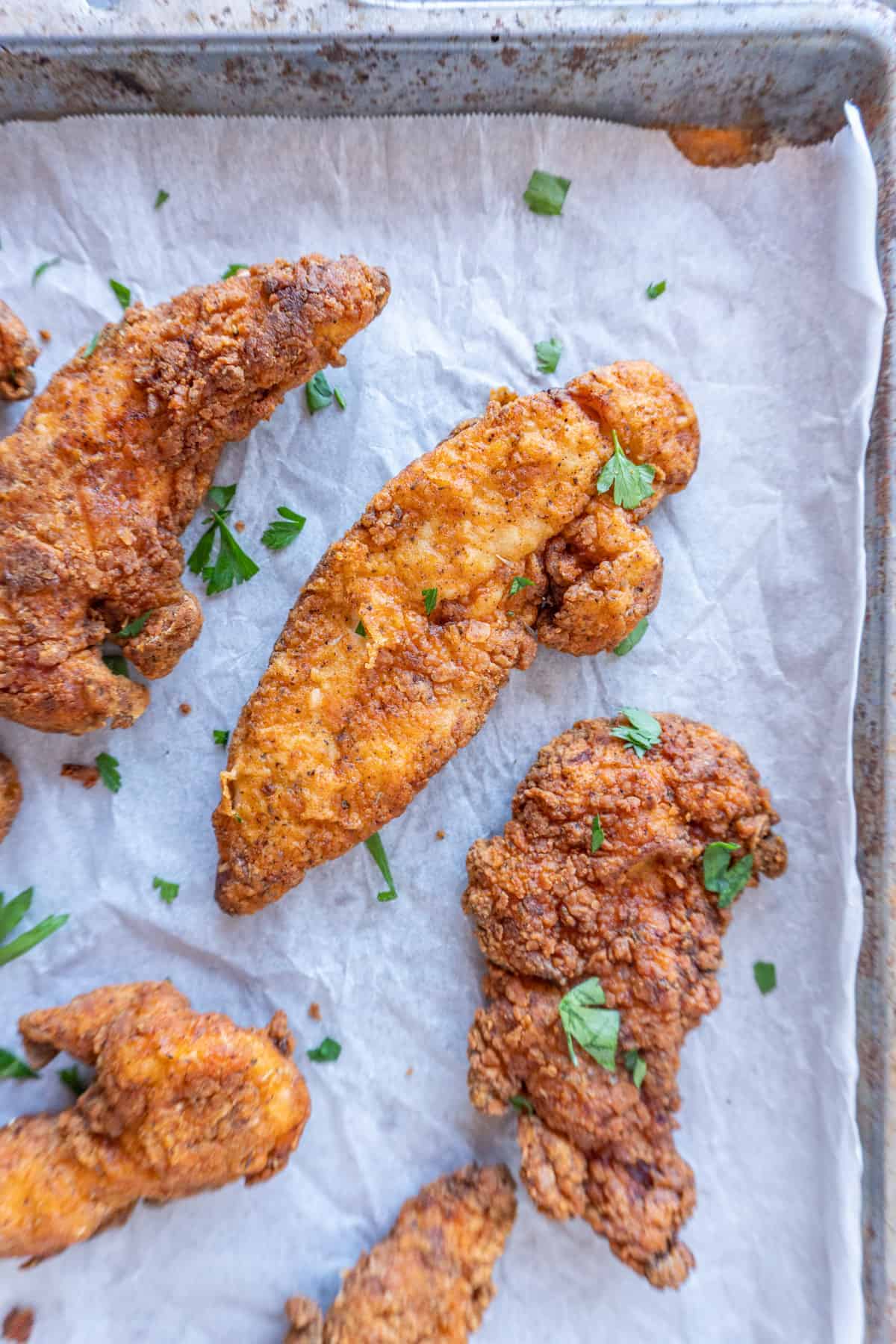 Chicken Tenders on baking tray with parsley pieces