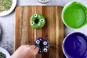 adding eyes and sprinkles to monster donuts