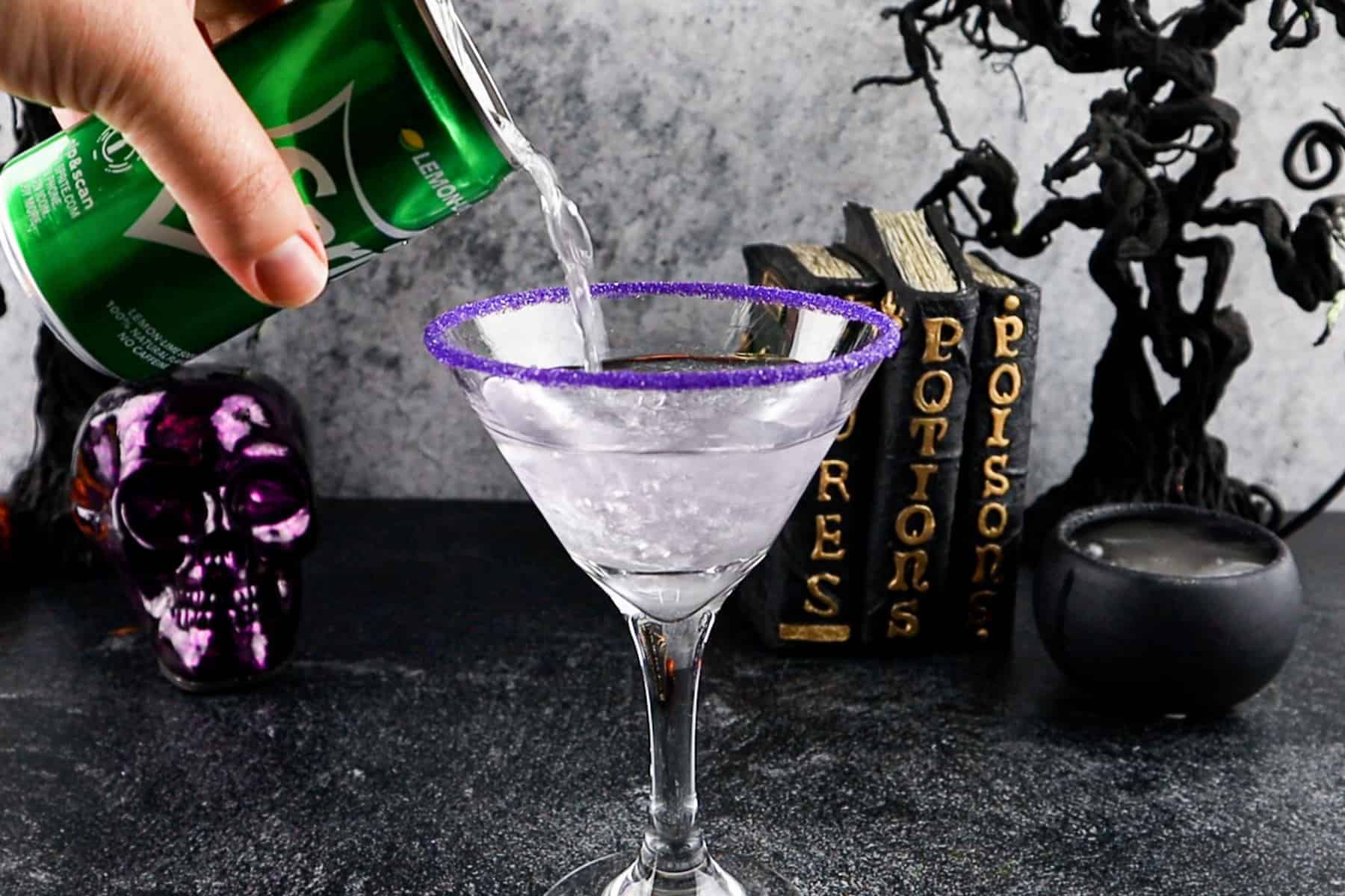 Adding Sprite to a Martini glass, Halloween decorations in the background.